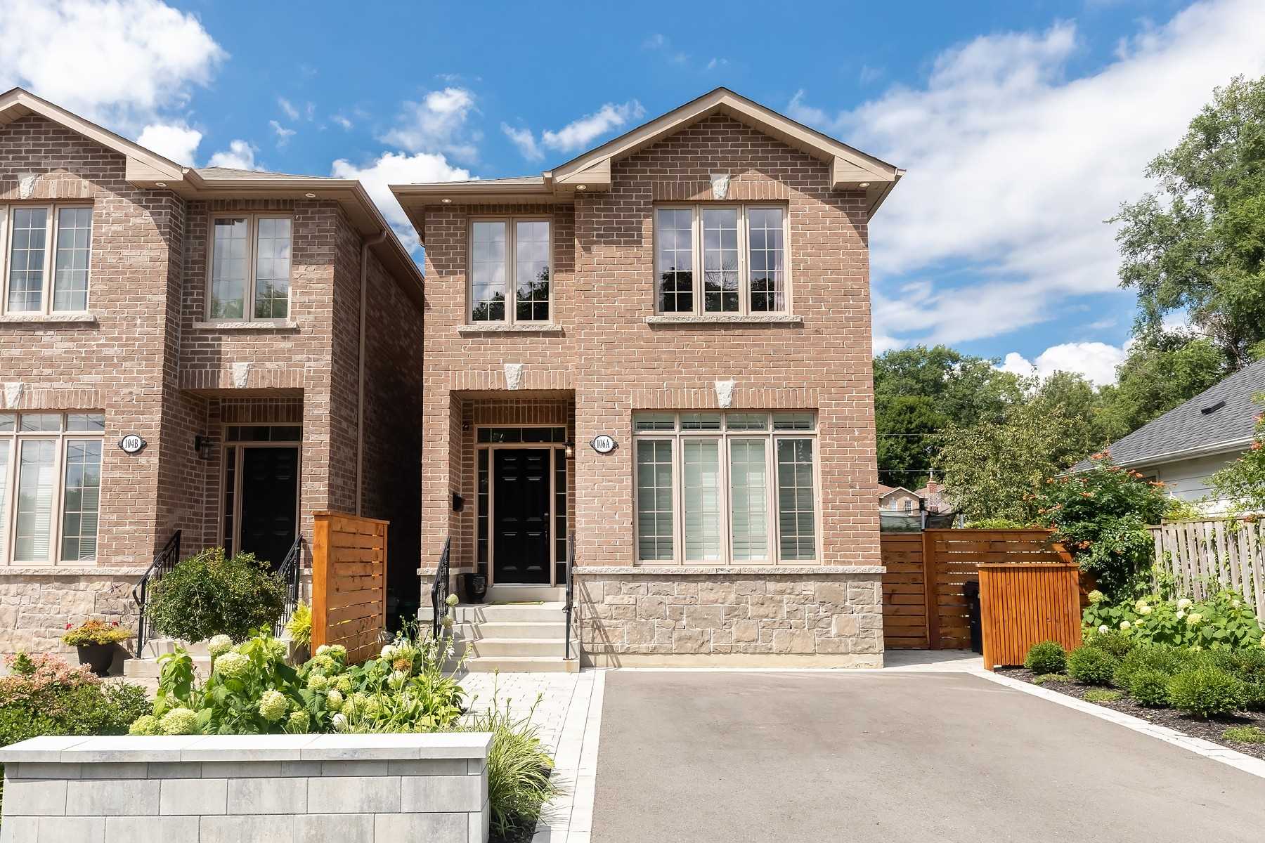Front exterior of the custom-built brick and stone home at 106A Hollis Avenue, Toronto, with landscaped gardens and a private drive