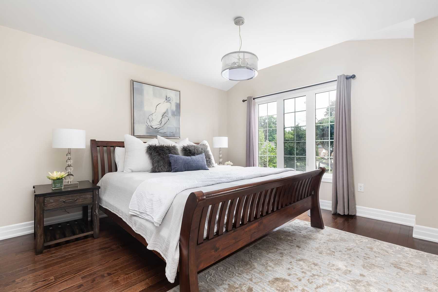 Master bedroom at 106A Hollis Avenue with a dark wood sleigh bed and tall windows