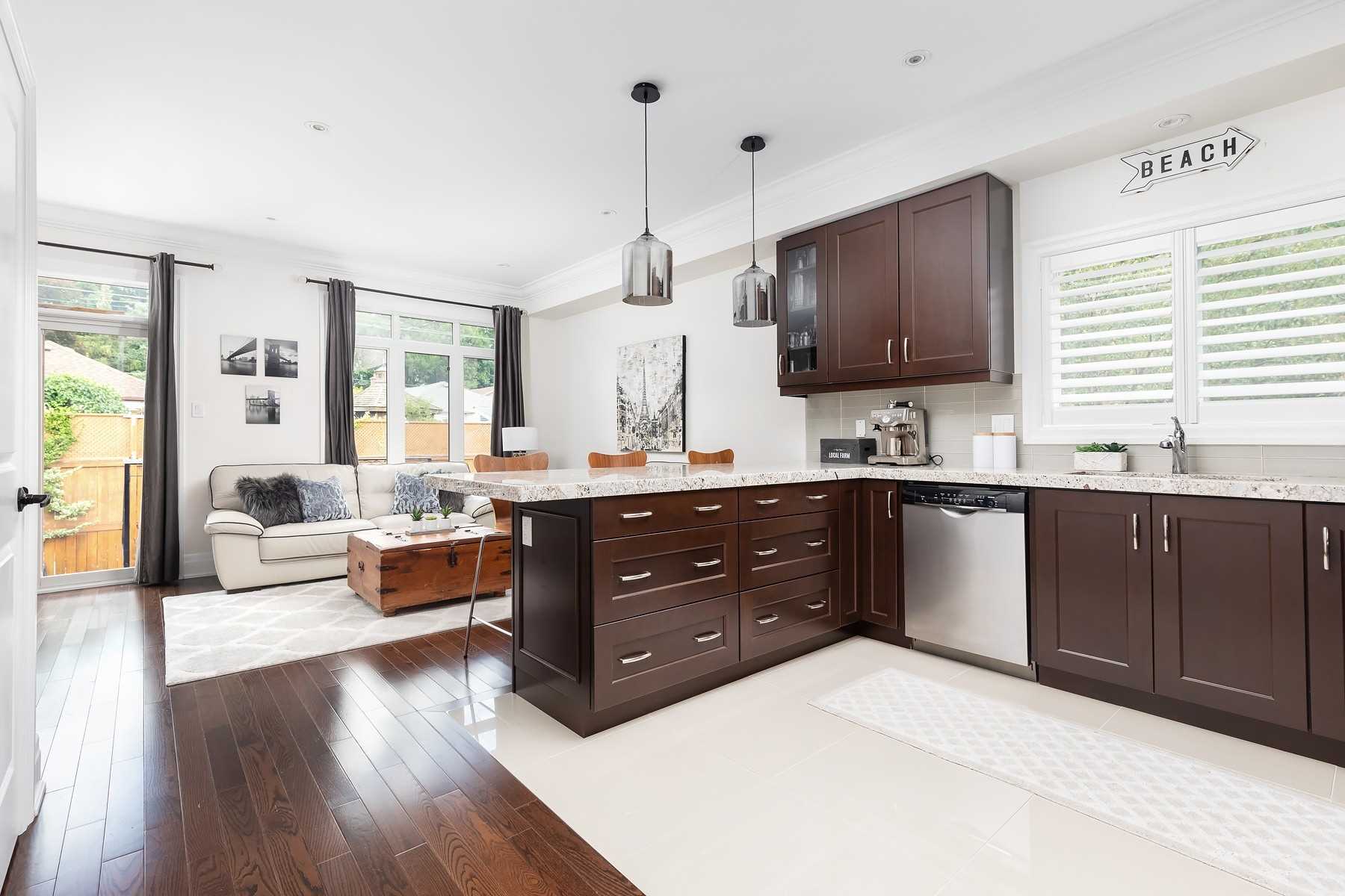Chef's kitchen at 106A Hollis Avenue with dark wood cabinets, granite island, and stainless steel appliances