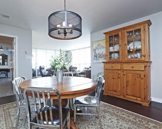 Dining room with round wood table, metal chairs, and drum pendant light