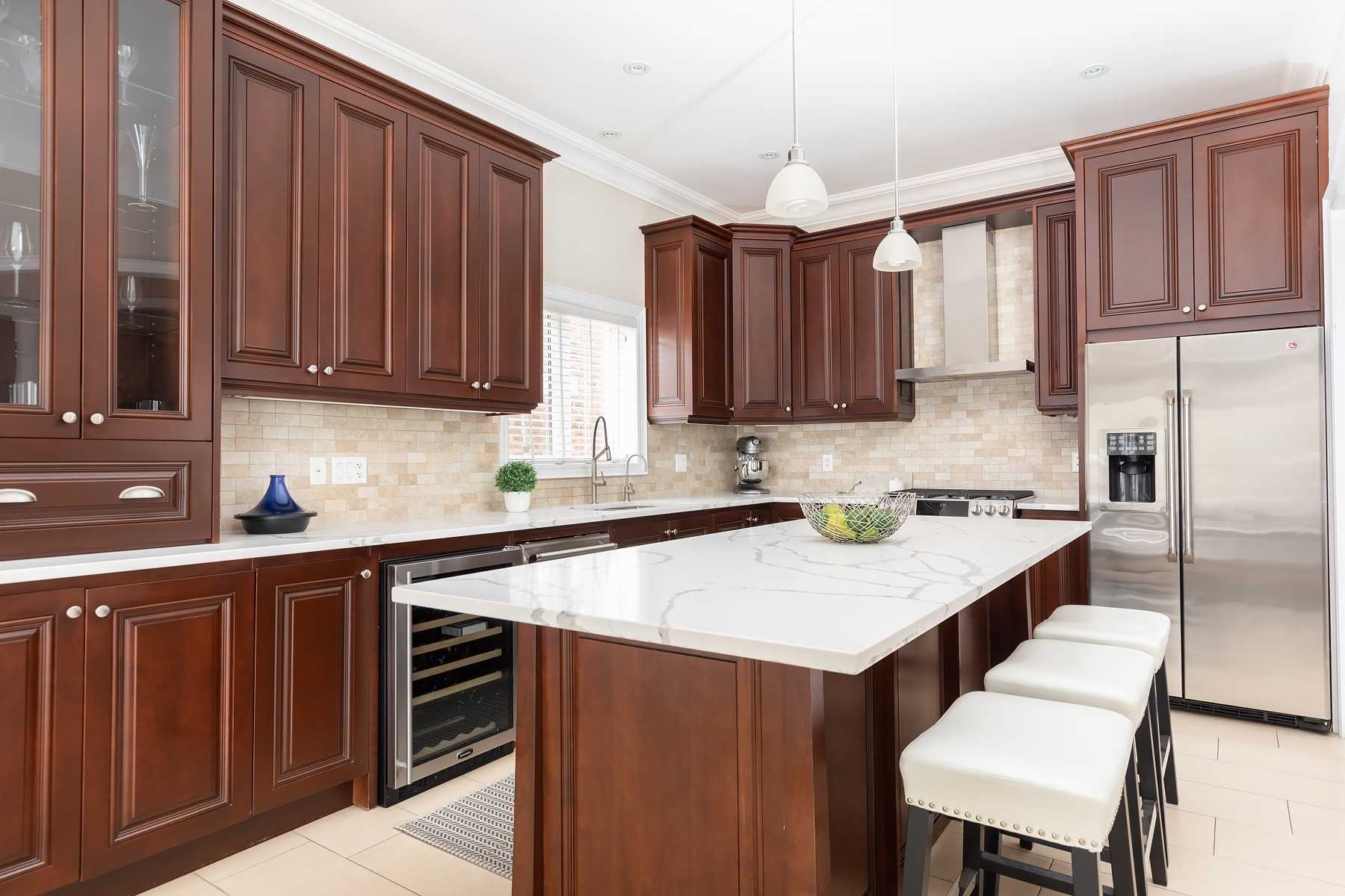 Kitchen of 33 Noce Way with cherry cabinetry, a large island, and stainless steel appliances