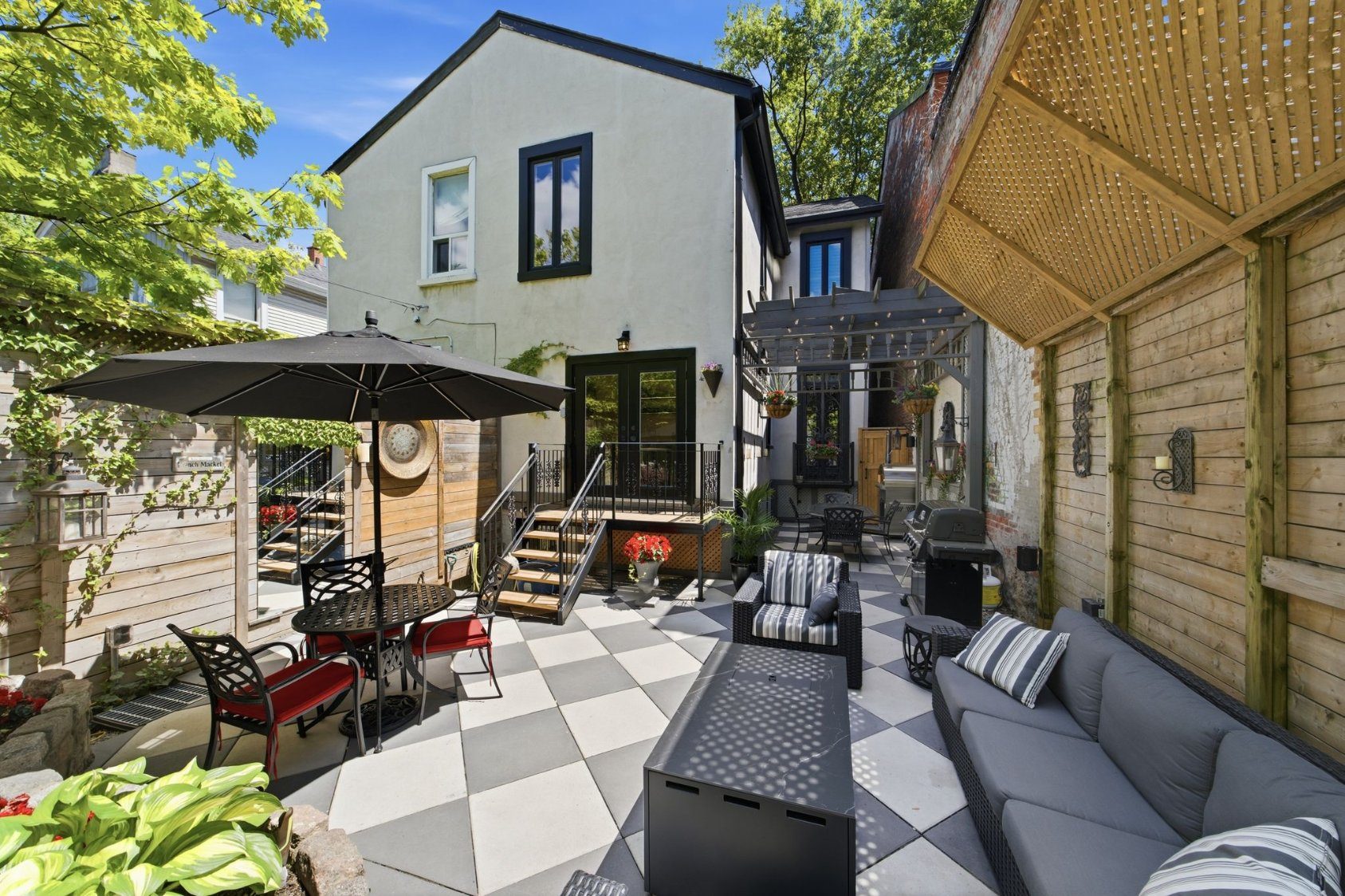Secluded courtyard with pergola, dining terrace, and pizza oven