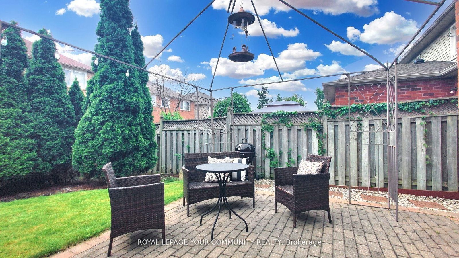 The backyard patio at 3374 Scotch Pine Gate &mdash; a private gazebo with string lights, mature cedars and a fully fenced yard