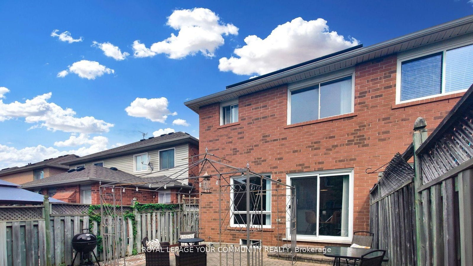 The rear exterior of 3374 Scotch Pine Gate &mdash; red-brick facade with a walk-out to the backyard patio