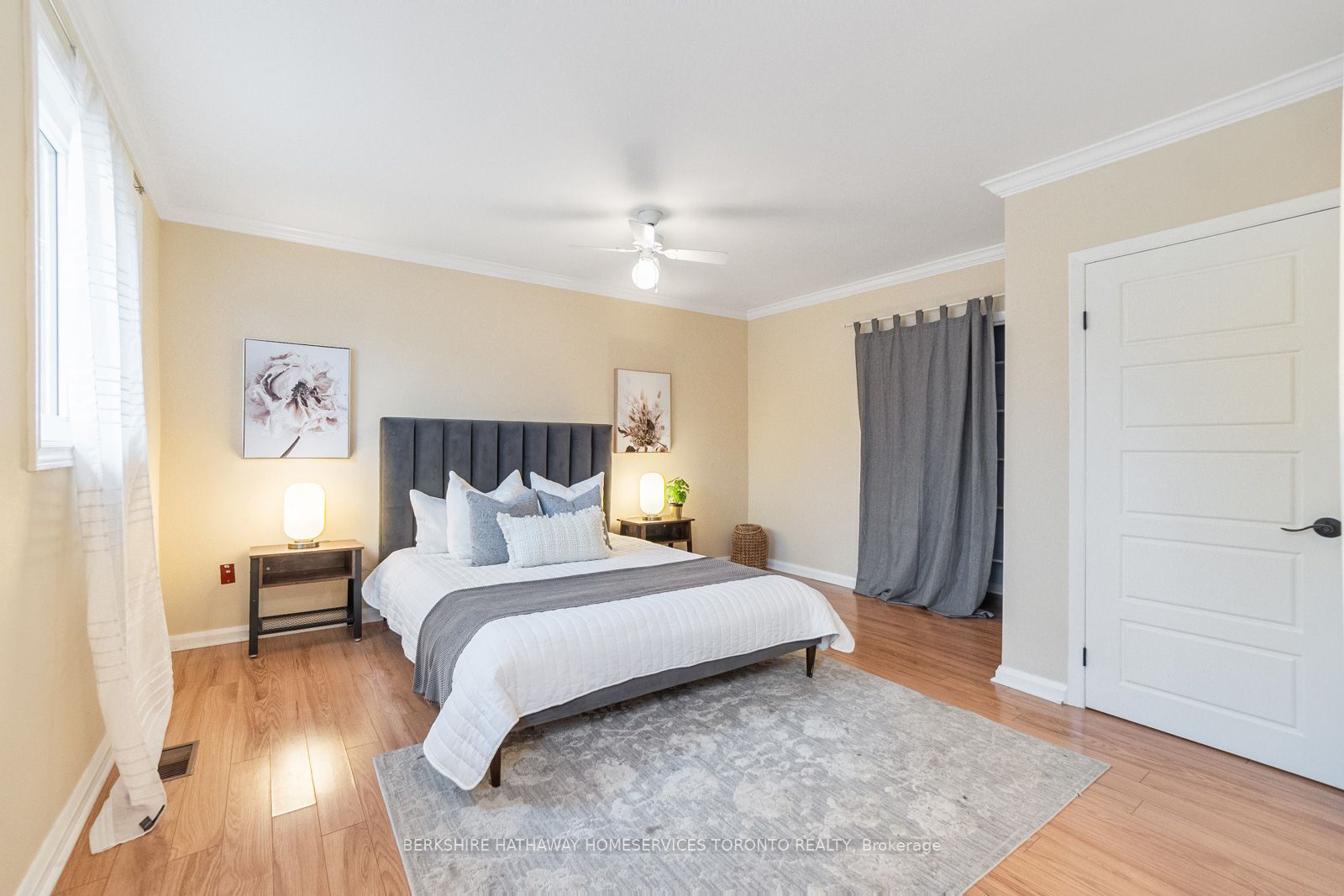 Primary suite with upholstered headboard, nightstands, and hardwood floors