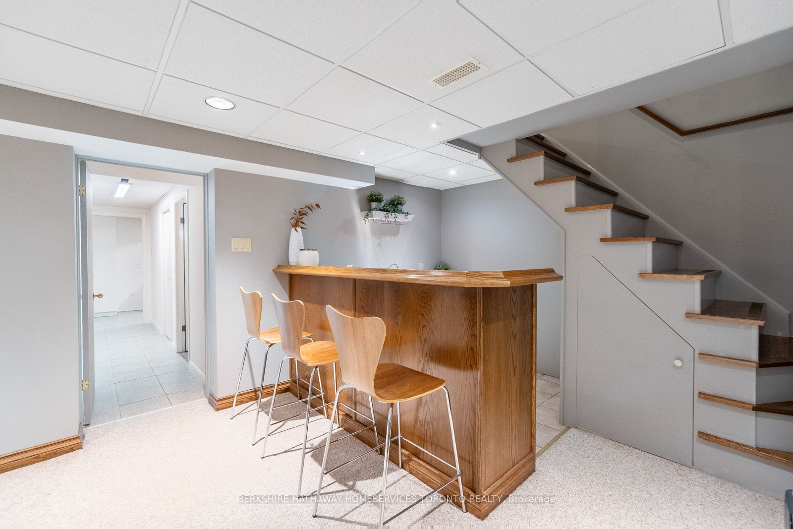 Lower-level bar with wooden stools beside the staircase