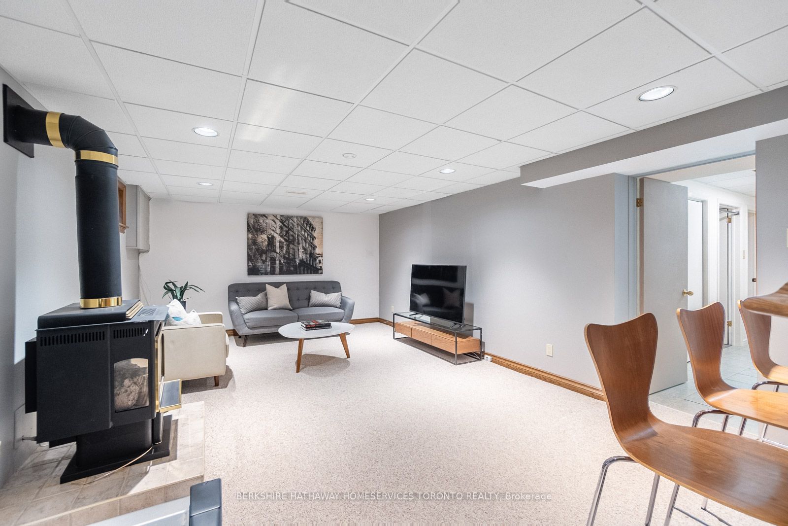 Lower-level rec room with gas fireplace, sofa, and television