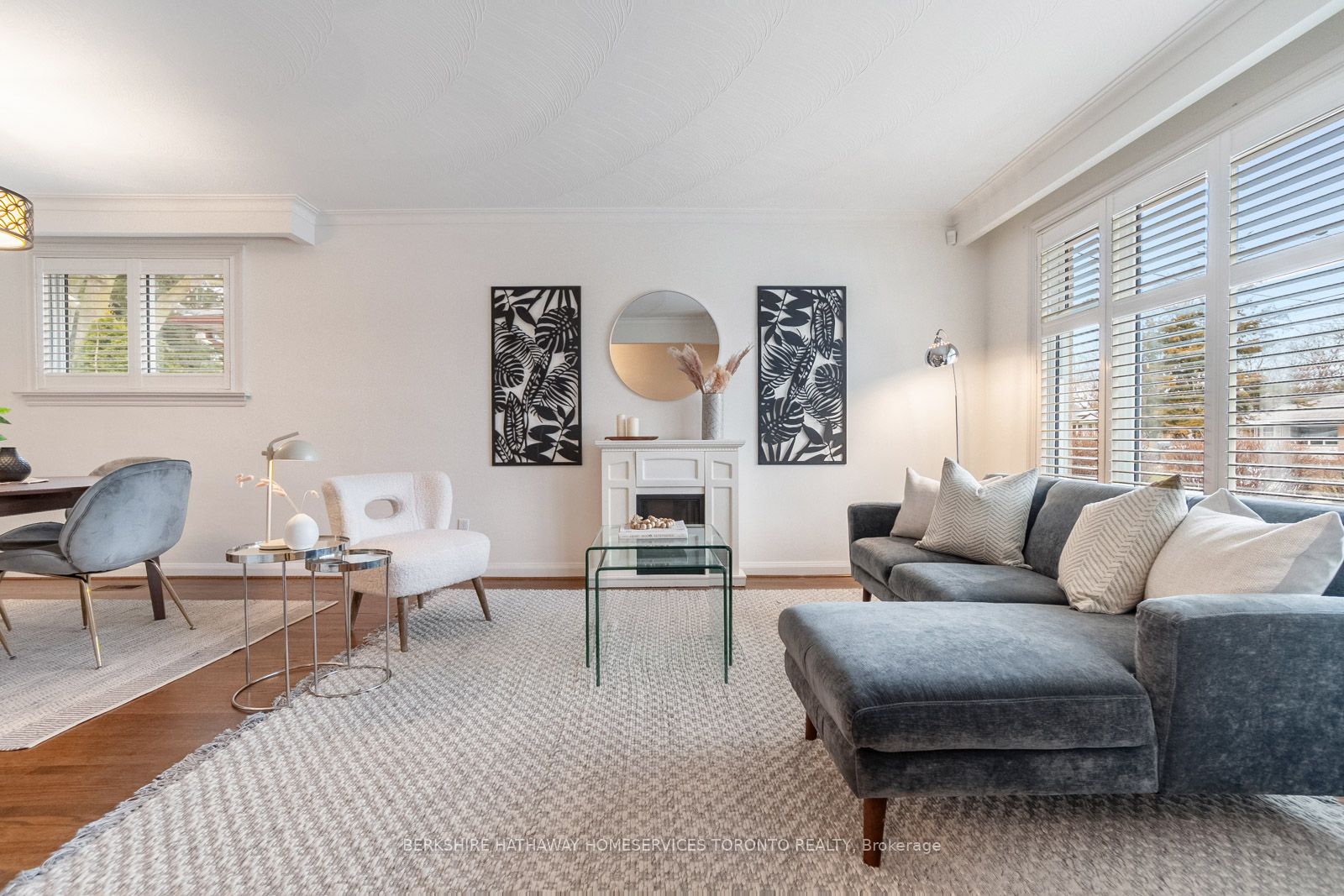 Bright staged living room with fireplace, shutters, and hardwood floors at 402 Osiris Drive