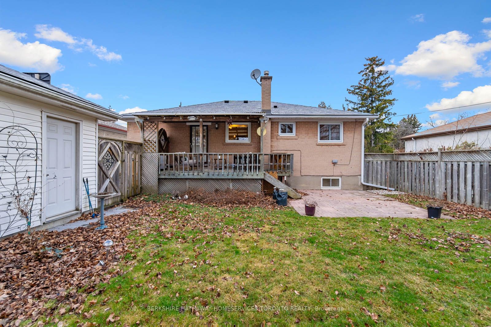 Rear of the brick bungalow with covered deck, patio, and detached garage