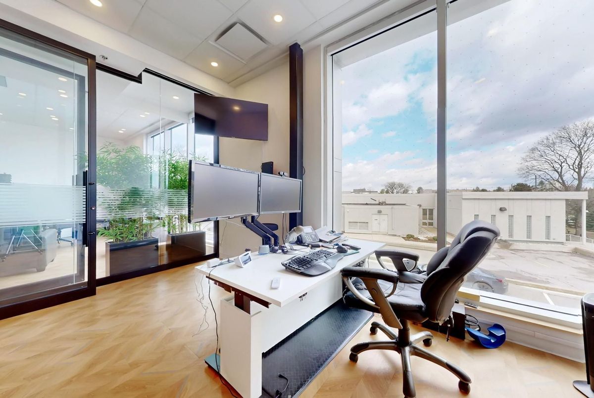 Private office with floor-to-ceiling windows and dual monitors