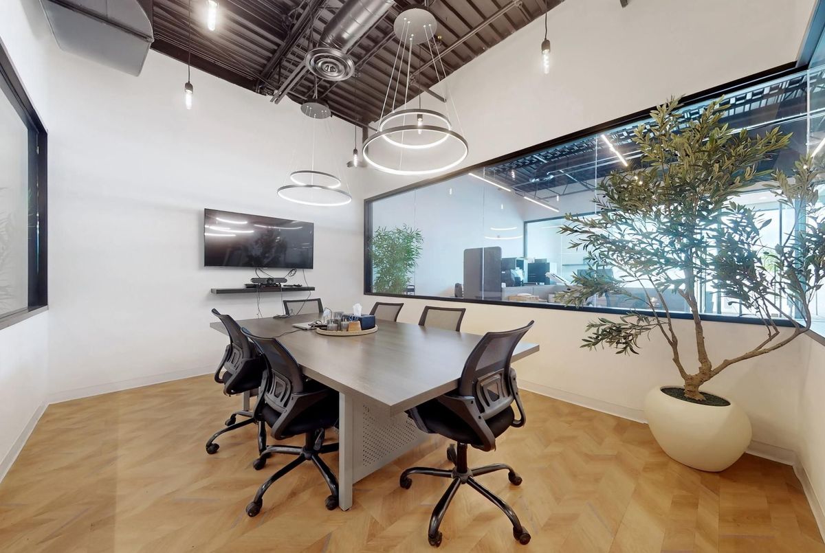 Glass-enclosed boardroom with modern pendant lighting