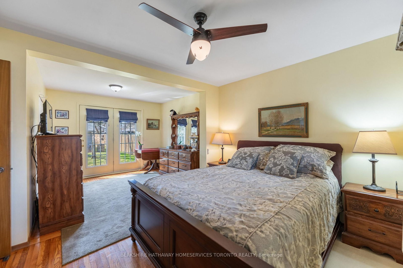 Primary bedroom with queen bed and French doors opening to the backyard