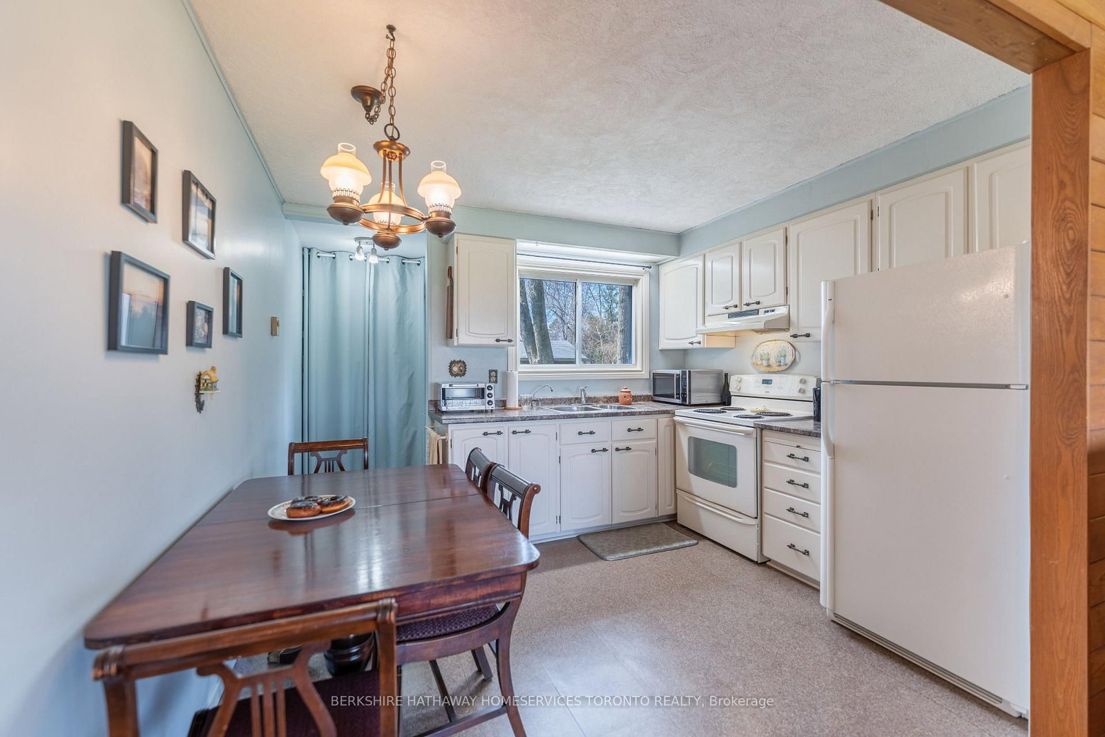 Bright eat-in kitchen with white cabinetry and dining table
