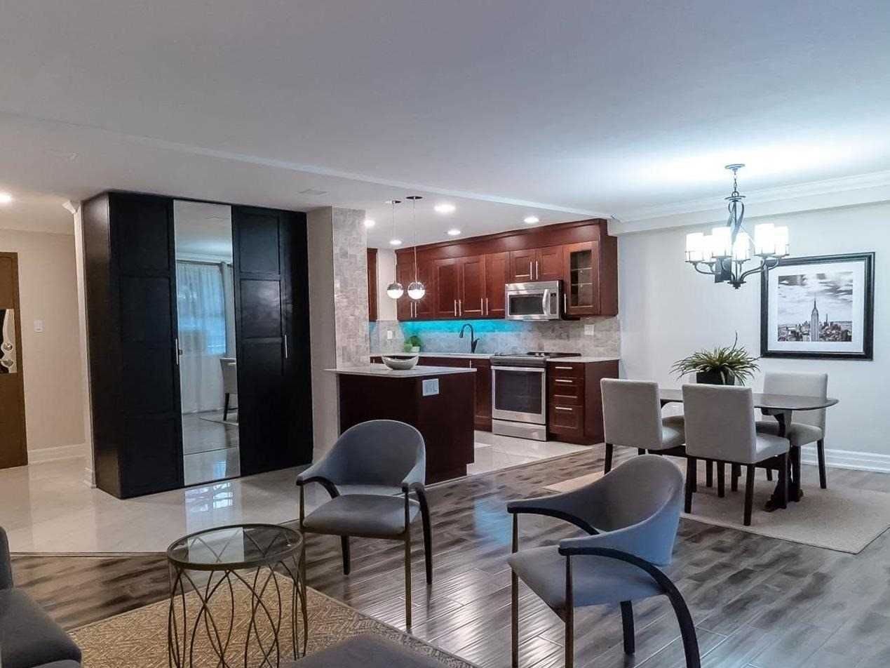 Open-concept living, dining and kitchen with wood-look floors at 210 - 80 Inverlochy Blvd, Markham