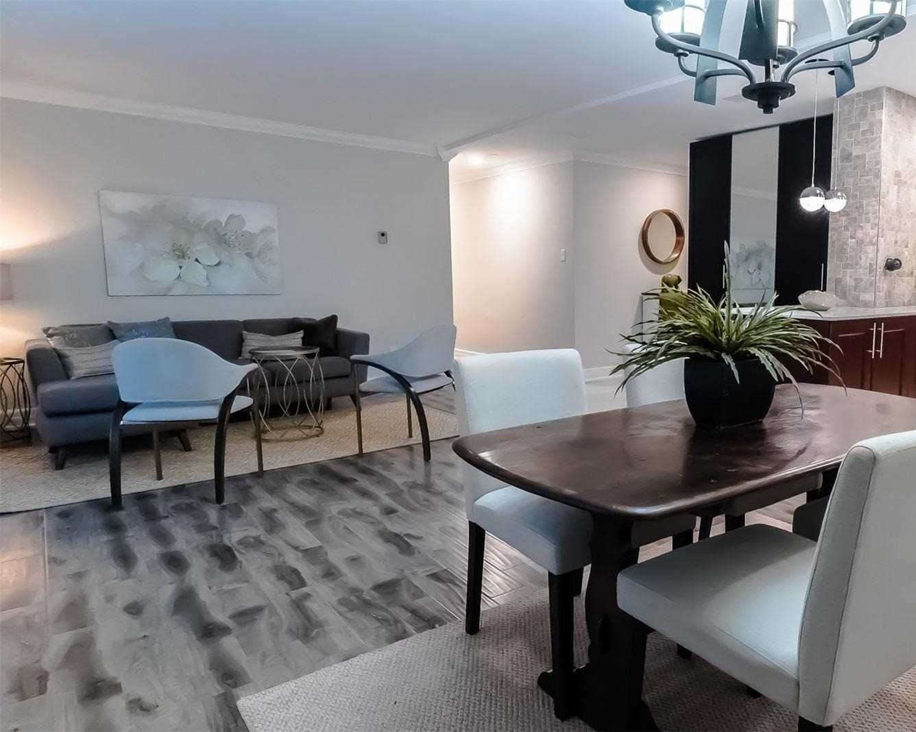 Living room with grey sofa, dining table and chandelier