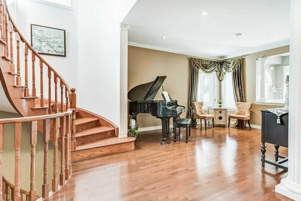 Curved hardwood staircase beside the formal living room with grand piano at 81 Alamo Heights Drive